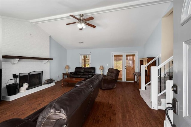 living area featuring french doors, vaulted ceiling with beams, a fireplace, wood finished floors, and stairs