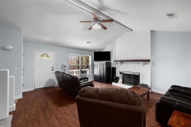 living room with visible vents, ceiling fan, wood finished floors, vaulted ceiling with beams, and a brick fireplace