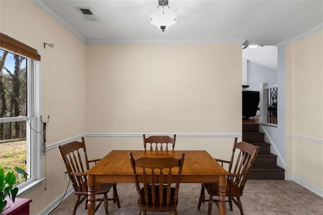 tiled dining space featuring visible vents, crown molding, and baseboards