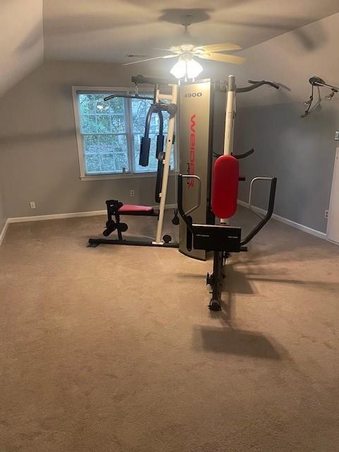 workout room with baseboards, ceiling fan, carpet, and vaulted ceiling