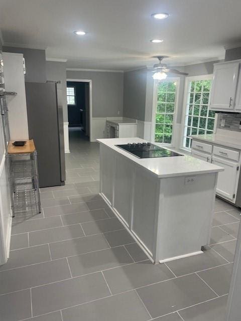 kitchen featuring ceiling fan, light countertops, black electric cooktop, freestanding refrigerator, and recessed lighting