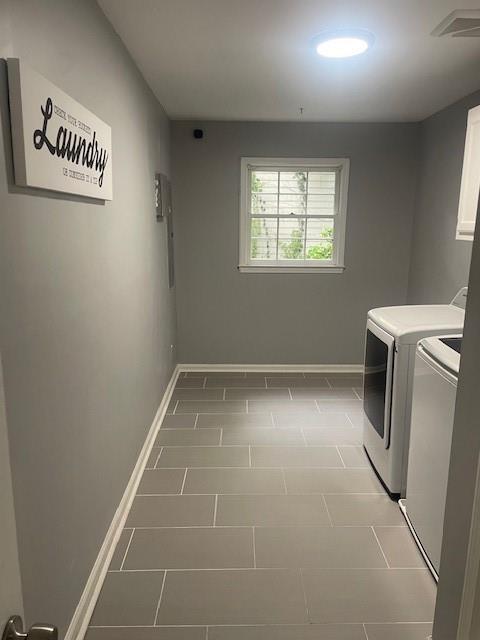 clothes washing area with cabinet space, baseboards, visible vents, and washer and clothes dryer