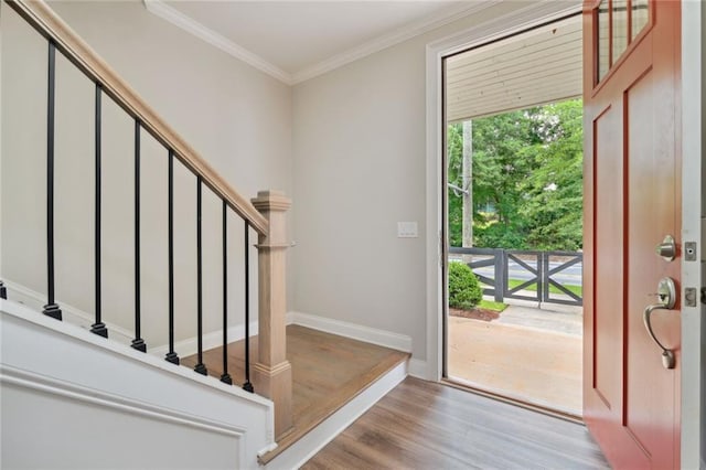 foyer entrance with light hardwood / wood-style flooring and crown molding