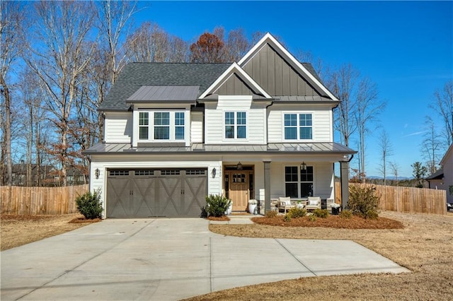 craftsman inspired home with covered porch, fence, driveway, board and batten siding, and a standing seam roof