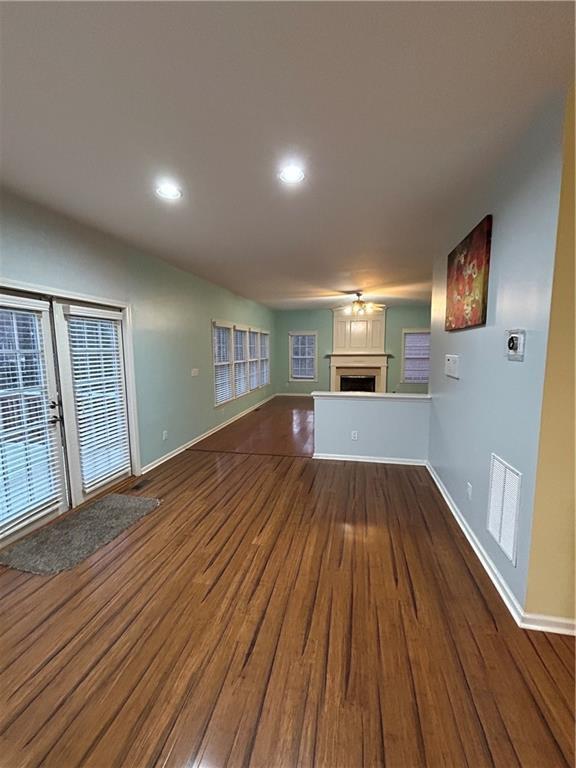 unfurnished living room featuring visible vents, baseboards, dark wood finished floors, recessed lighting, and a fireplace