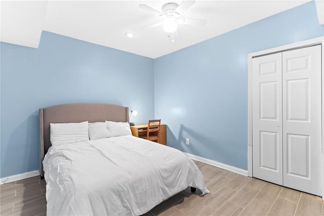 bedroom featuring a closet, a ceiling fan, baseboards, and wood tiled floor