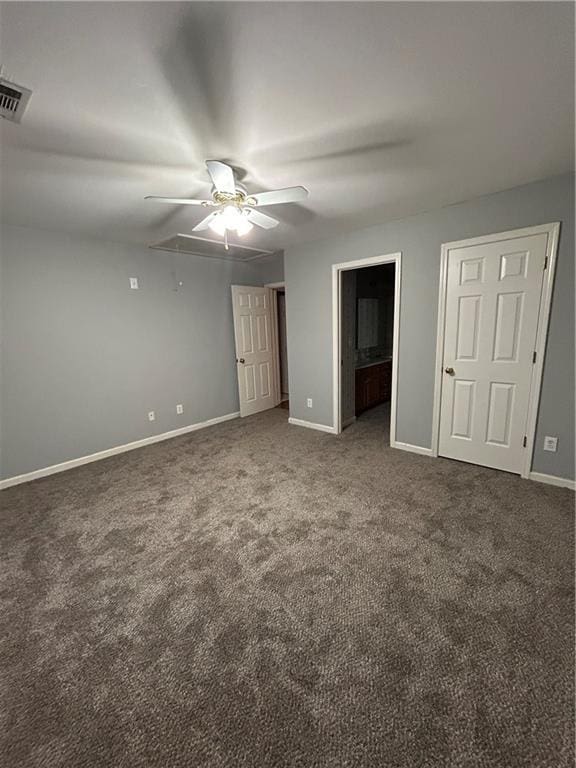 unfurnished bedroom with visible vents, carpet flooring, baseboards, attic access, and ceiling fan