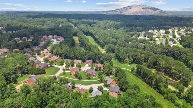 drone / aerial view with a view of trees, a mountain view, and a residential view