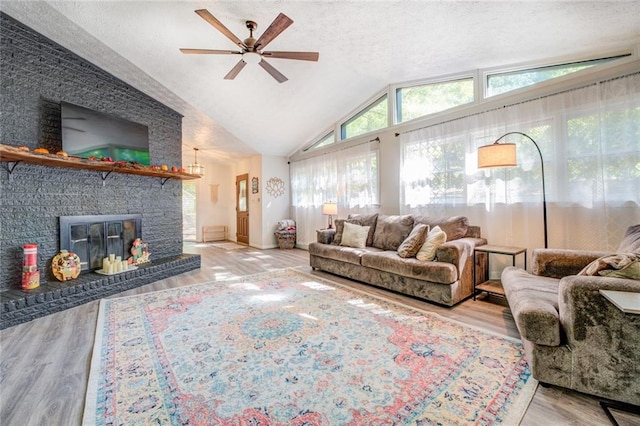 1019 Whippoorwill Rd, Monticello, GA 31064 - living area featuring ceiling fan, lofted ceiling, wood finished floors, a brick fireplace, and a textured ceiling