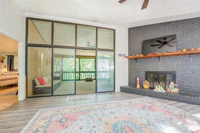 1019 Whippoorwill Rd, Monticello, GA 31064 - living room with a ceiling fan, wood finished floors, and a brick fireplace