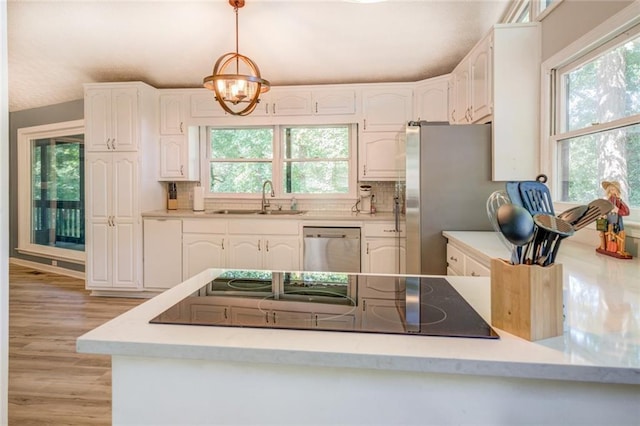 1019 Whippoorwill Rd, Monticello, GA 31064 - kitchen with stainless steel appliances, white cabinets, and a chandelier