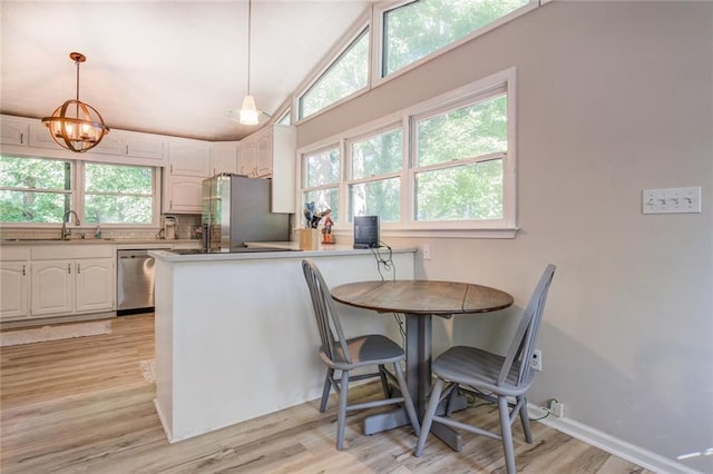 1019 Whippoorwill Rd, Monticello, GA 31064 - kitchen featuring stainless steel appliances, white cabinets, light wood-type flooring, a peninsula, and vaulted ceiling