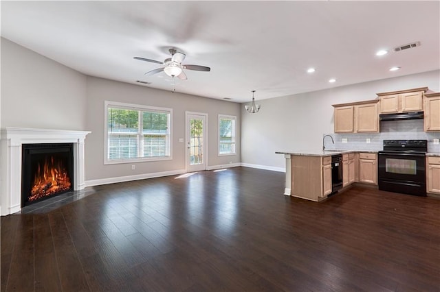 kitchen featuring light brown cabinetry, black appliances, sink, dark hardwood / wood-style flooring, and kitchen peninsula