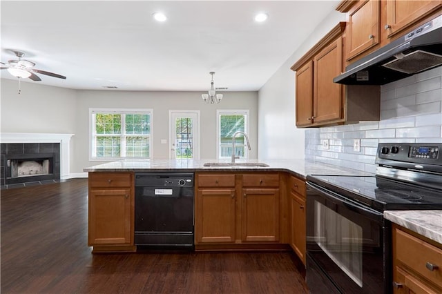 kitchen with a healthy amount of sunlight, sink, a fireplace, and black appliances