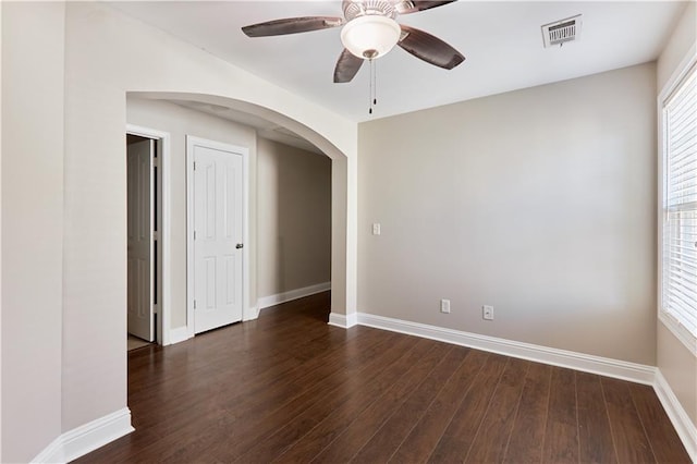 empty room featuring dark wood-type flooring and ceiling fan