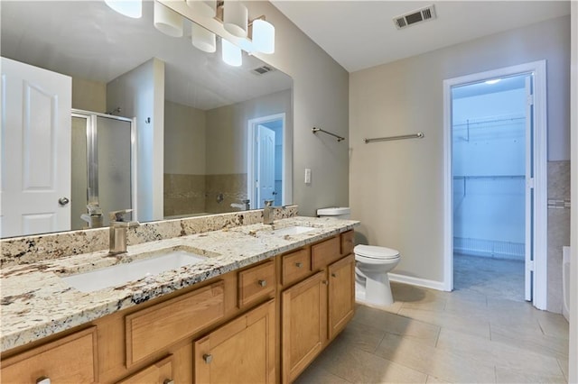 bathroom featuring vanity, a shower with shower door, and toilet