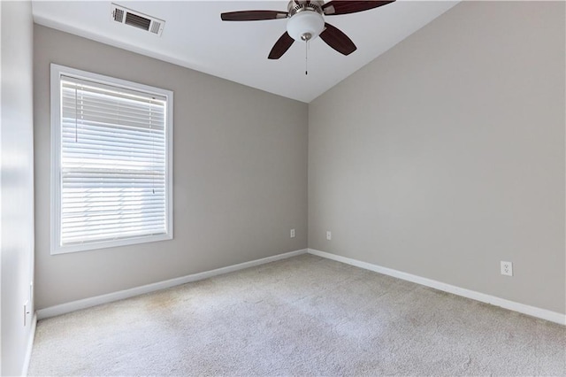 carpeted spare room featuring lofted ceiling and ceiling fan