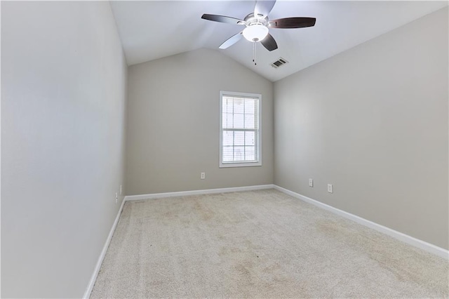 spare room featuring ceiling fan, light colored carpet, and vaulted ceiling