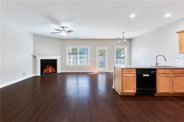 kitchen featuring ceiling fan with notable chandelier, dishwasher, sink, hanging light fixtures, and dark wood-type flooring