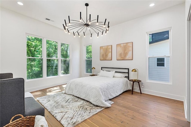 bedroom featuring an inviting chandelier and hardwood / wood-style floors