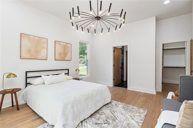 bedroom with wood-type flooring and a notable chandelier