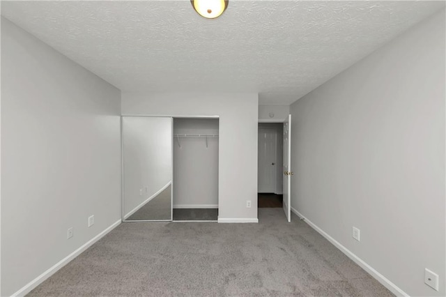 unfurnished bedroom featuring a textured ceiling, a closet, and carpet floors