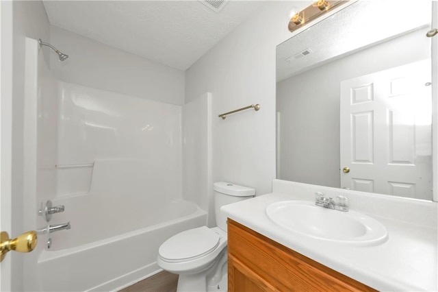 full bathroom with wood-type flooring, vanity, a textured ceiling, bathtub / shower combination, and toilet