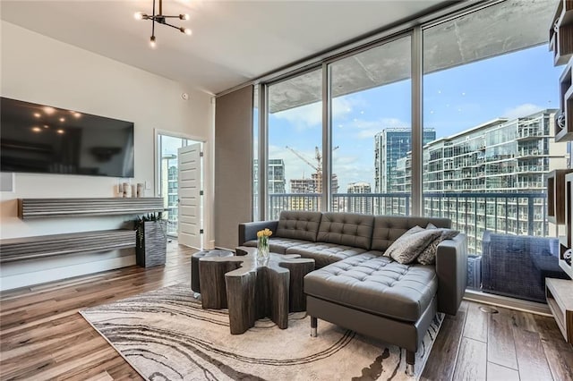 living room with a city view, a wall of windows, and wood finished floors