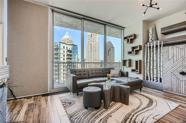 living area with a wall of windows, an inviting chandelier, a view of city, and wood finished floors