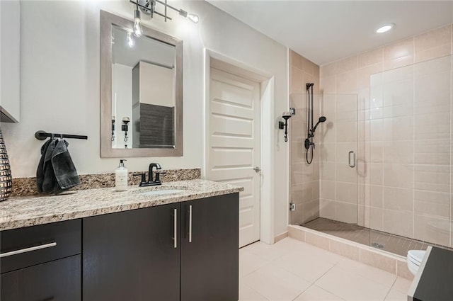 bathroom with vanity, recessed lighting, tile patterned flooring, a shower stall, and toilet