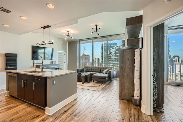 kitchen with visible vents, dishwasher, light wood-style floors, and a sink