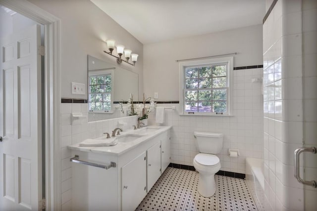 bathroom with a wealth of natural light, vanity, and tile walls