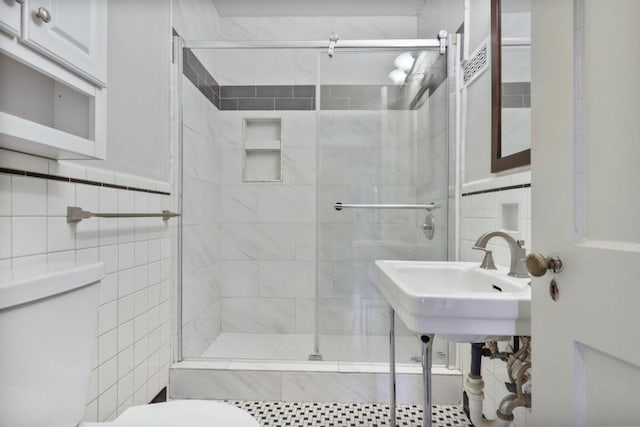 bathroom featuring toilet, tile walls, and walk in shower