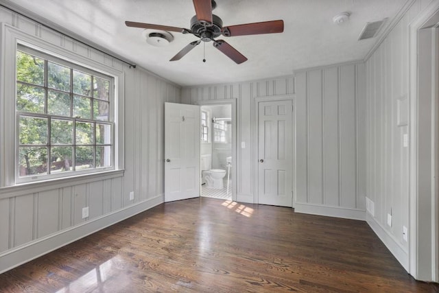 unfurnished bedroom with ensuite bath, ceiling fan, dark hardwood / wood-style flooring, and crown molding