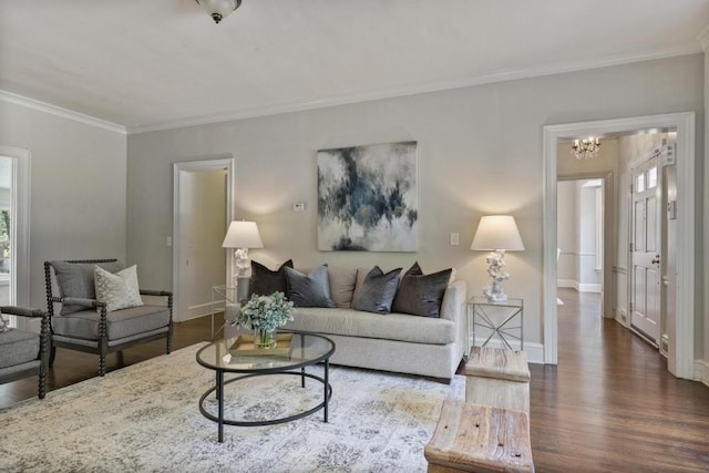 living room featuring dark hardwood / wood-style flooring, a chandelier, and ornamental molding