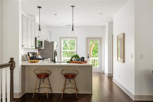 1196 Wylie St SE, Atlanta, GA 30316 - kitchen featuring appliances with stainless steel finishes, dark wood-type flooring, white cabinets, a peninsula, and light countertops