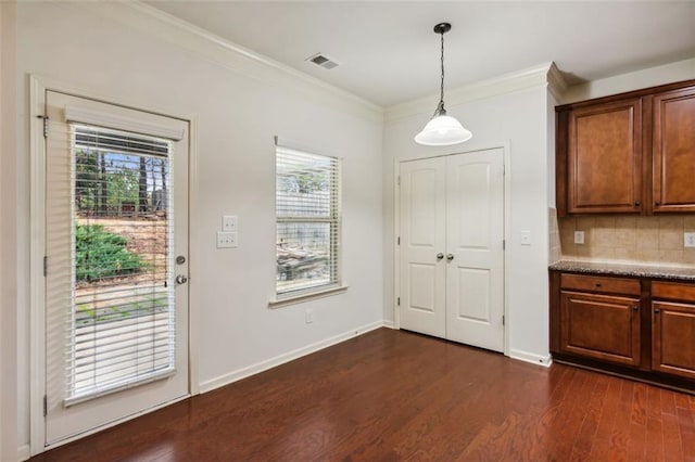 interior space featuring plenty of natural light, crown molding, and dark wood-type flooring