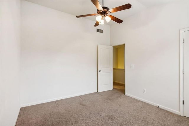 carpeted empty room with ceiling fan and high vaulted ceiling