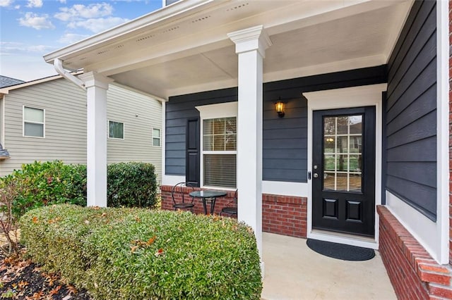 view of exterior entry featuring covered porch