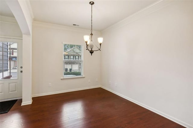 unfurnished dining area with a chandelier, crown molding, a wealth of natural light, and dark wood-type flooring