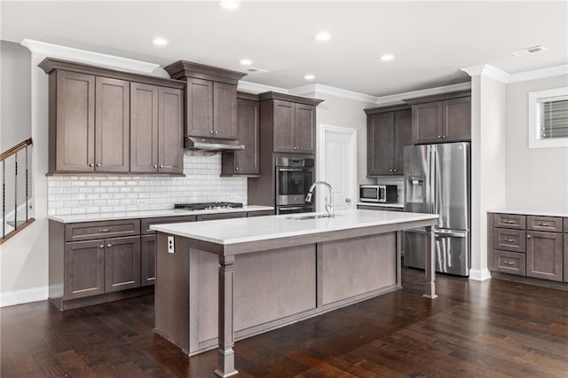 kitchen featuring a kitchen island with sink, dark wood-type flooring, stainless steel appliances, and dark brown cabinetry