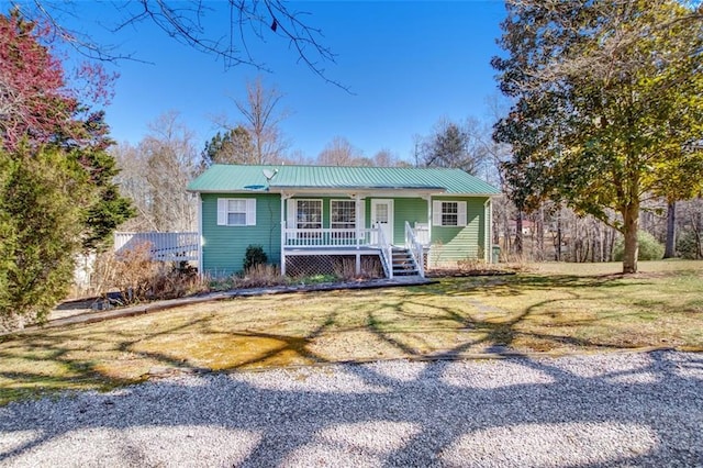 view of front of property featuring a front lawn, covered porch, and metal roof