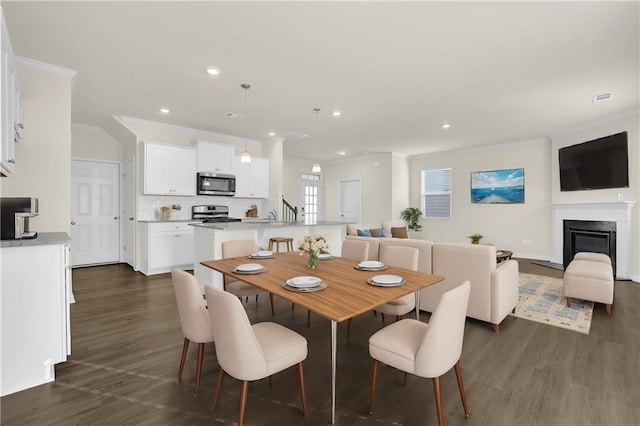 dining space with dark hardwood / wood-style flooring and crown molding