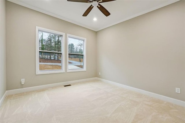 empty room with light carpet, ceiling fan, and ornamental molding