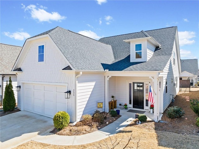 view of front facade with concrete driveway, a shingled roof, and a garage