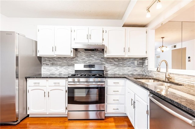 2901 Lenox Way NE Unit 902, Atlanta, GA 30324 - kitchen with appliances with stainless steel finishes, a sink, under cabinet range hood, dark stone counters, and white cabinetry