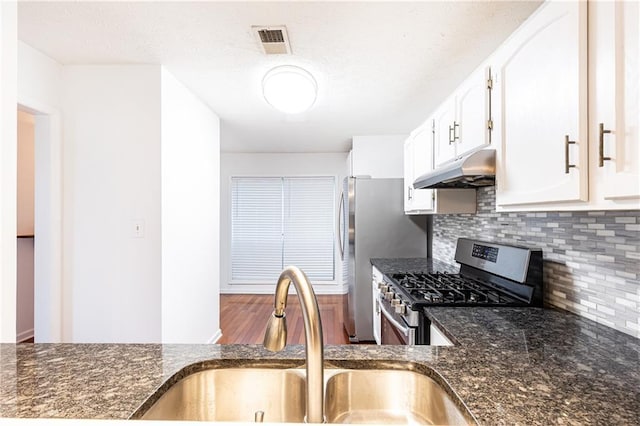 2901 Lenox Way NE Unit 902, Atlanta, GA 30324 - kitchen featuring under cabinet range hood, stainless steel appliances, a sink, dark stone counters, and backsplash