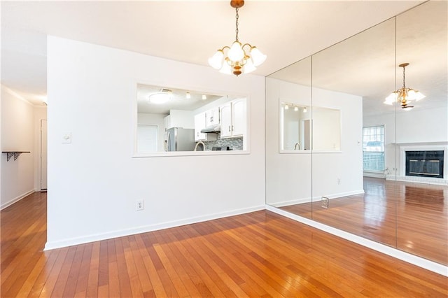 2901 Lenox Way NE Unit 902, Atlanta, GA 30324 - unfurnished living room featuring a chandelier, hardwood / wood-style floors, and baseboards