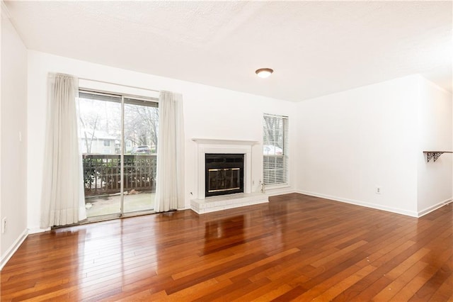 2901 Lenox Way NE Unit 902, Atlanta, GA 30324 - unfurnished living room with hardwood / wood-style floors, a glass covered fireplace, and baseboards