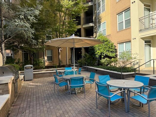 view of patio / terrace featuring outdoor dining area, exterior kitchen, and grilling area